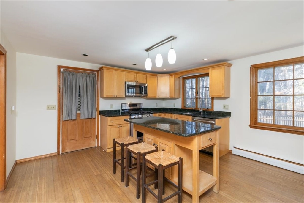 145 Warrenton Road Haverhill, MA 01832 - Photo 12 of 38 a kitchen with granite countertop wooden floors and white stainless steel appliances