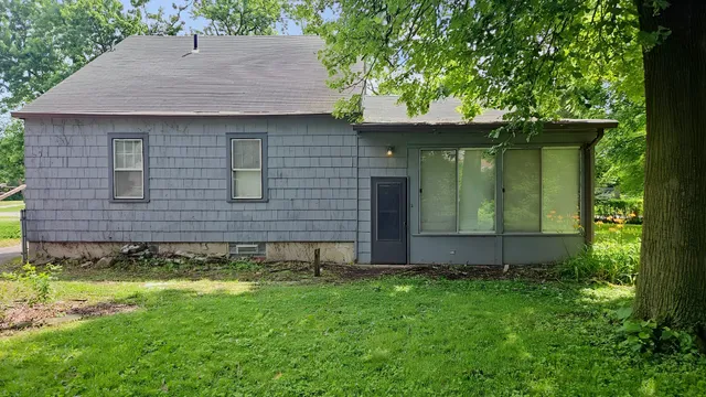a view of a backyard with plants and large trees
