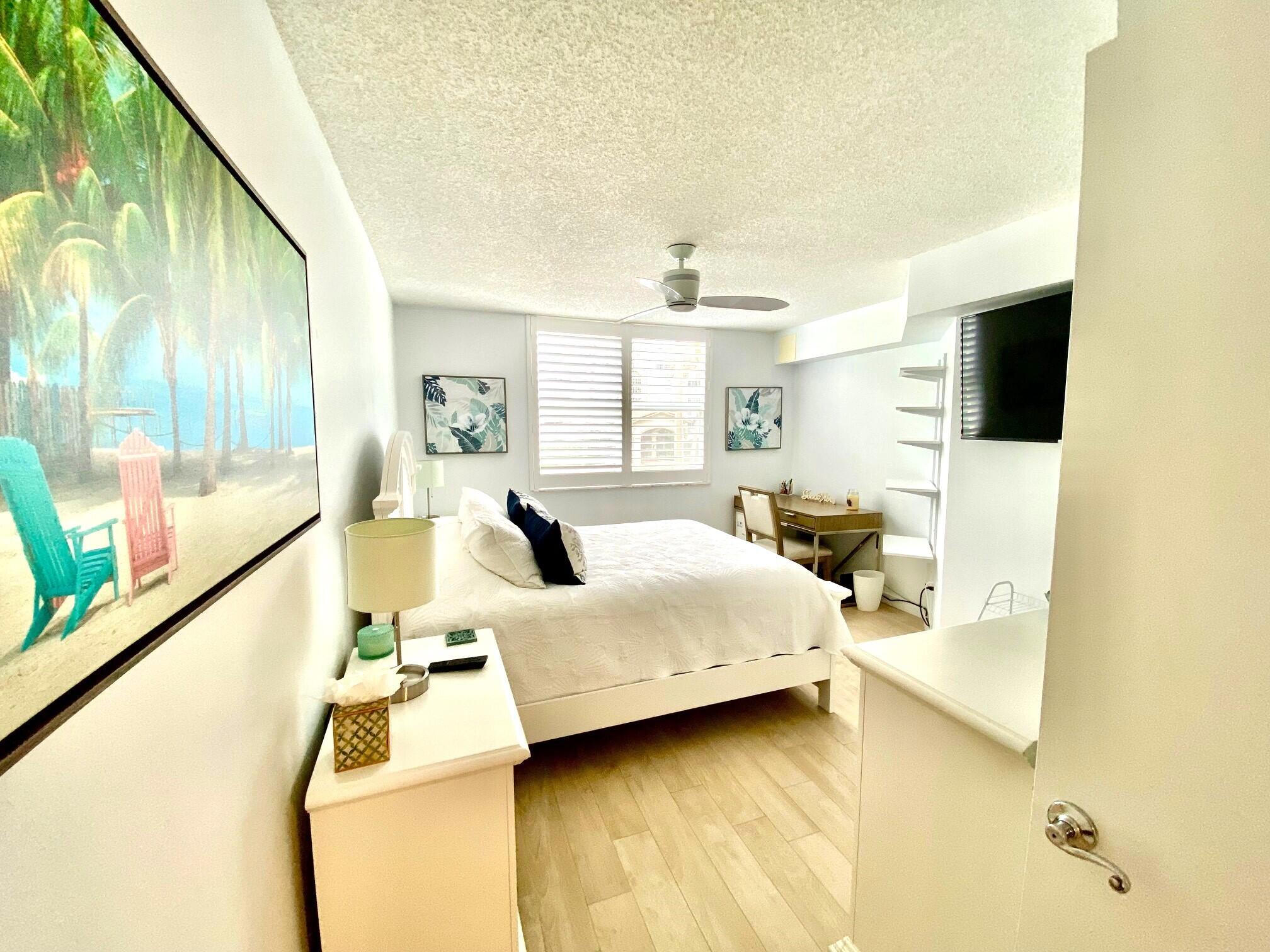 3594 South Ocean Boulevard, Unit 207 Highland Beach, FL 33487 - Photo 22 of 56 a bedroom with a bed and a flat tv screen next to a large window