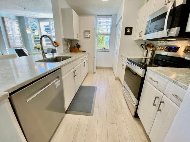 3594 South Ocean Boulevard, Unit 207 Highland Beach, FL 33487 - Photo 9 of 56 a kitchen with granite countertop white cabinets and sink