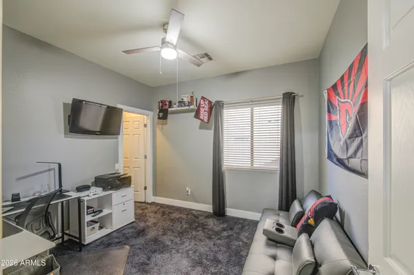 a bedroom with furniture and a chandelier fan