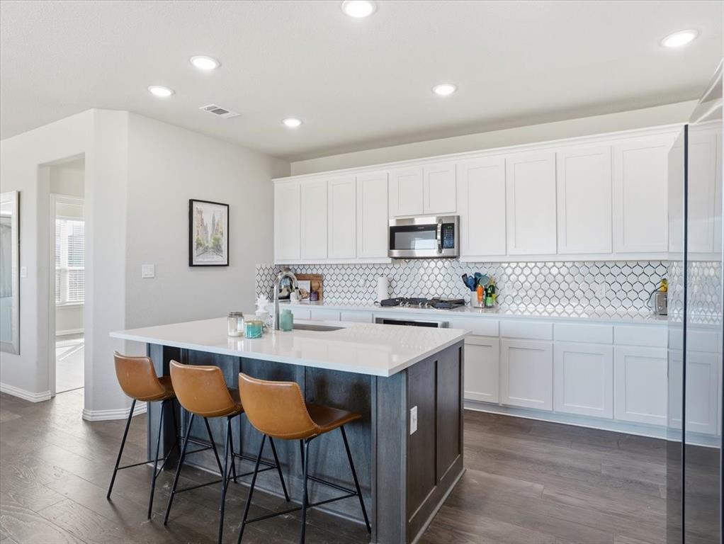 312 Welch Folly Lane Aledo, TX 76008 - Photo 11 of 33 a kitchen with stainless steel appliances kitchen island a table chairs sink and cabinets