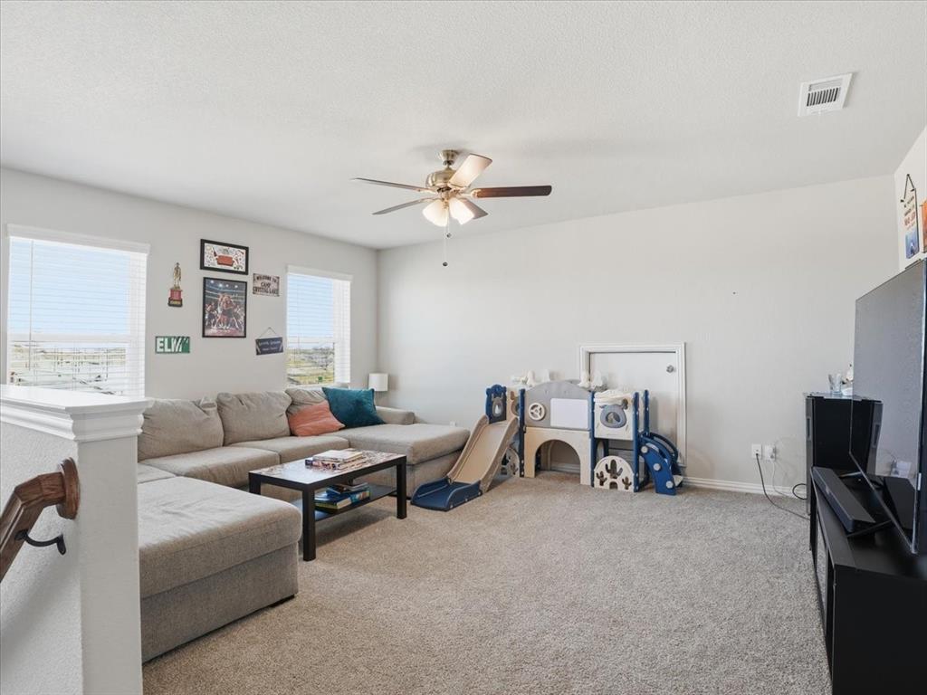 312 Welch Folly Lane Aledo, TX 76008 - Photo 21 of 33 a living room with furniture a flat screen tv and a ceiling fan