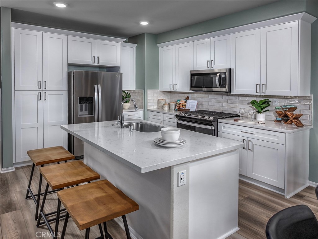 4869 Merida Way Oceanside, CA 92057 - Photo 2 of 13 a kitchen with stainless steel appliances a stove a sink a microwave a refrigerator and cabinets