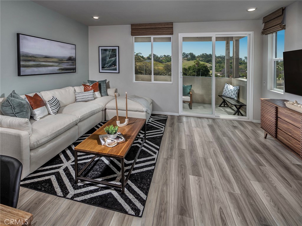 4869 Merida Way Oceanside, CA 92057 - Photo 5 of 13 a living room with furniture a flat screen tv and a floor to ceiling window