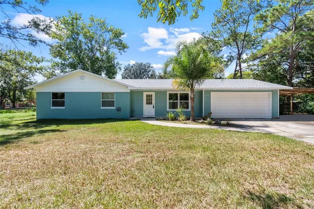 a view of a house with a yard and a tree