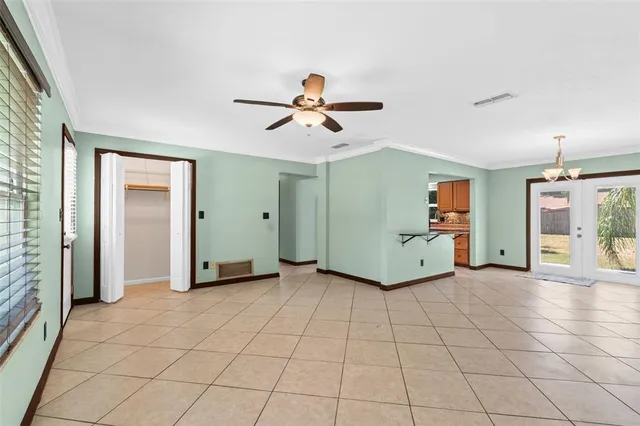 a view of a livingroom with a chandelier fan and windows