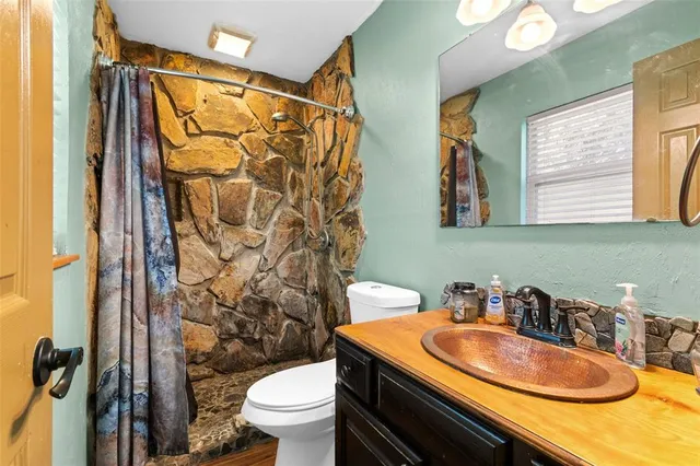 a bathroom with a sink a toilet and shower