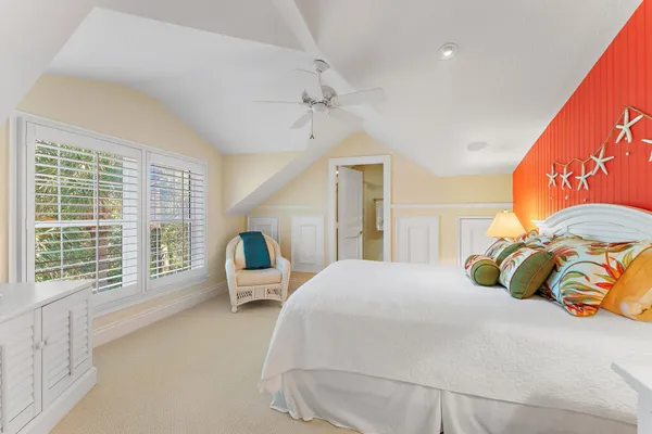 a bedroom with a bed mirror and window