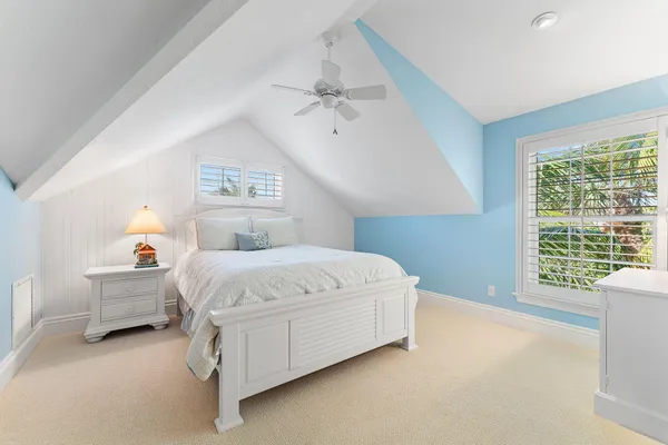 a bed sitting in a spacious bedroom next to a window