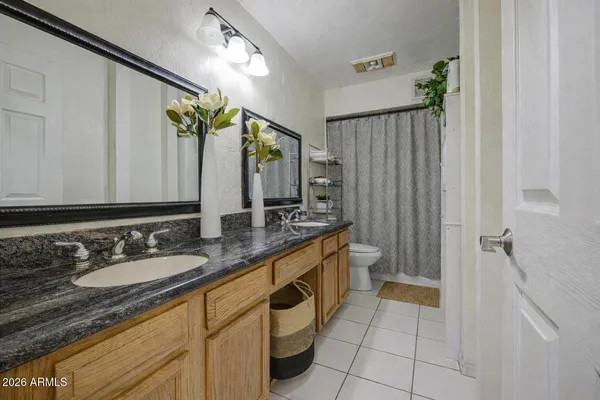 a spacious bathroom with a granite countertop sink and a mirror