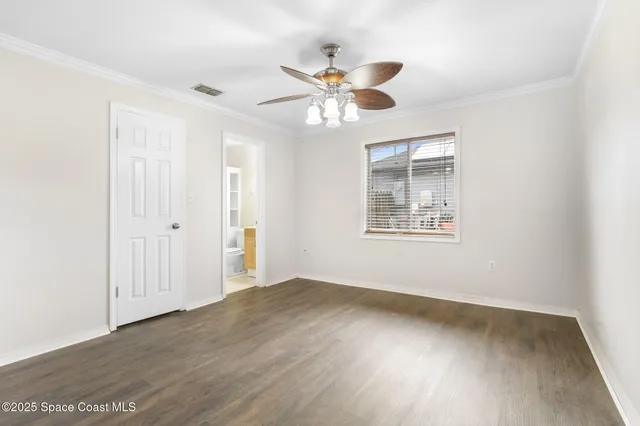 an empty room with a window and a ceiling fan