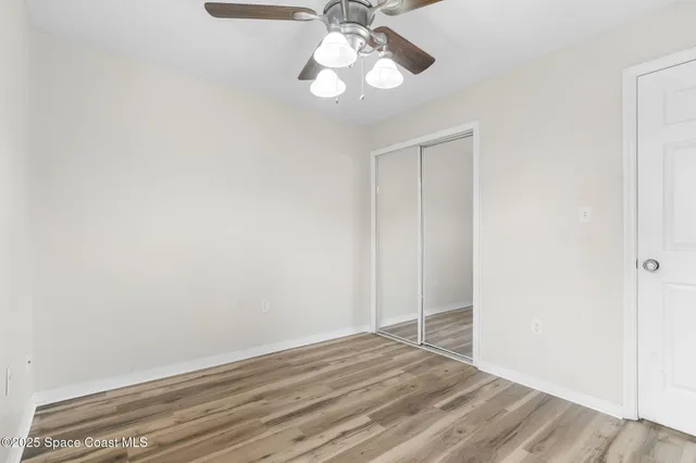 a view of empty room with wooden floor and window