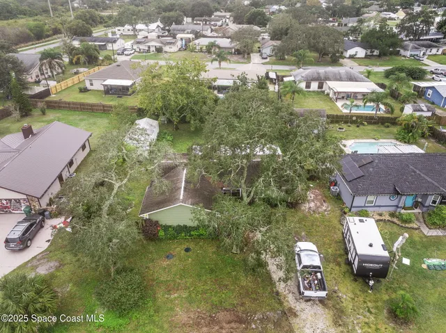 an aerial view of residential houses with outdoor space and trees