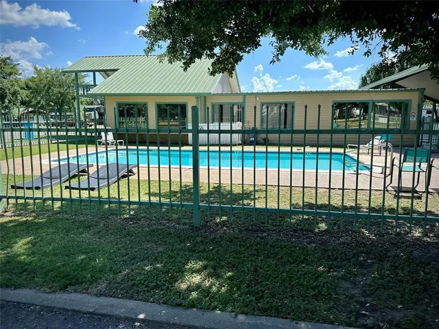 a view of a brick house with a big yard and potted plants