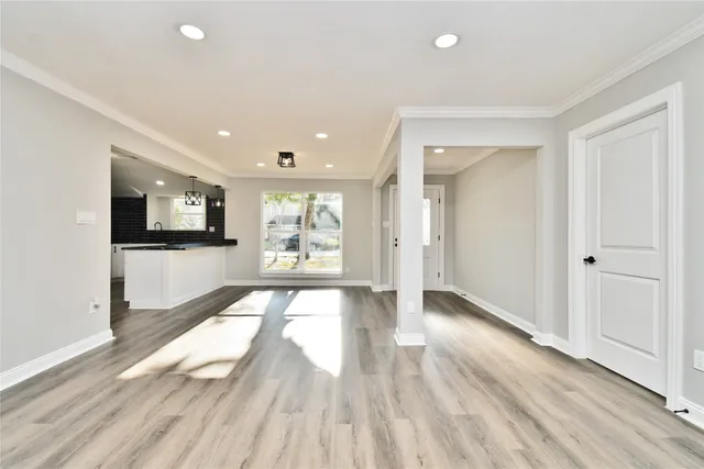 a view of a white house with a large tree