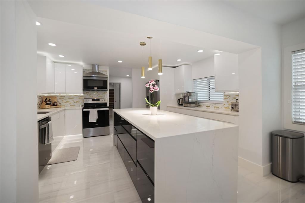 16015 Redington Drive Redington Beach, FL 33708 - Photo 14 of 60 a kitchen with kitchen island a sink stainless steel appliances and cabinets