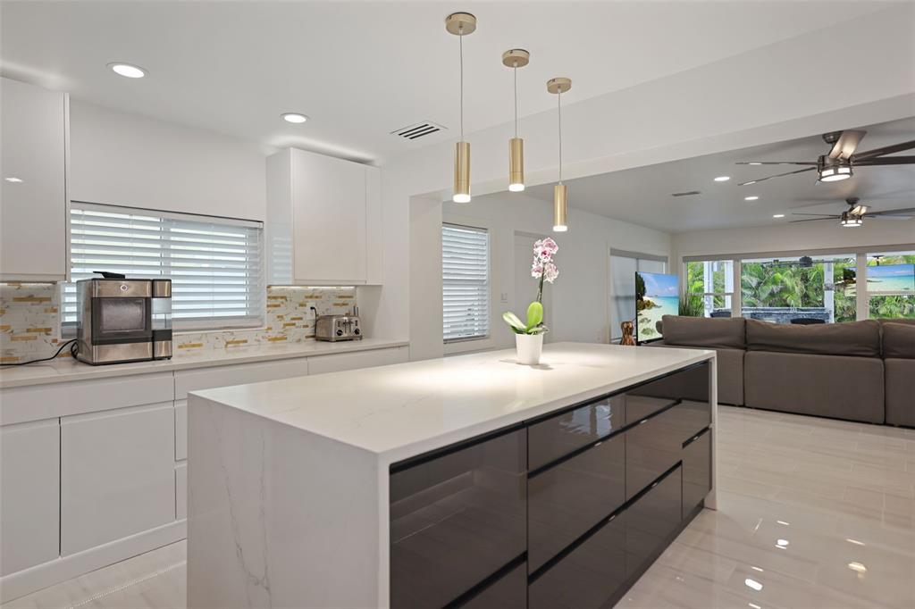16015 Redington Drive Redington Beach, FL 33708 - Photo 16 of 60 a kitchen with kitchen island a counter top space appliances and a ceiling fan
