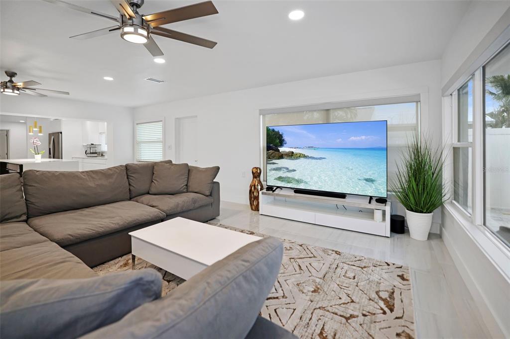 16015 Redington Drive Redington Beach, FL 33708 - Photo 21 of 60 a living room with furniture a chandelier and a flat screen tv
