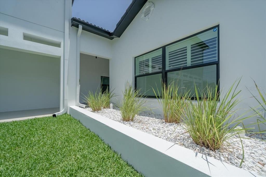 16015 Redington Drive Redington Beach, FL 33708 - Photo 8 of 60 a view of yellow house with a large window and potted plants