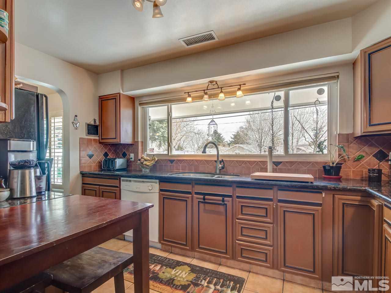 2345 Watt Street Reno, NV 89509 - Photo 9 of 25 a kitchen with kitchen island granite countertop a sink and cabinets