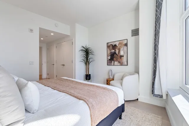 a bedroom with bed and a painting on the wall