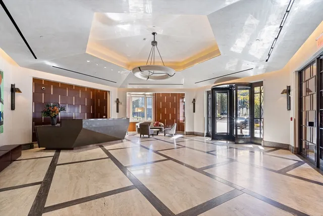 a living room with furniture a chandelier and a large window