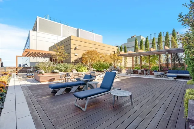 a roof deck with outdoor seating and city view