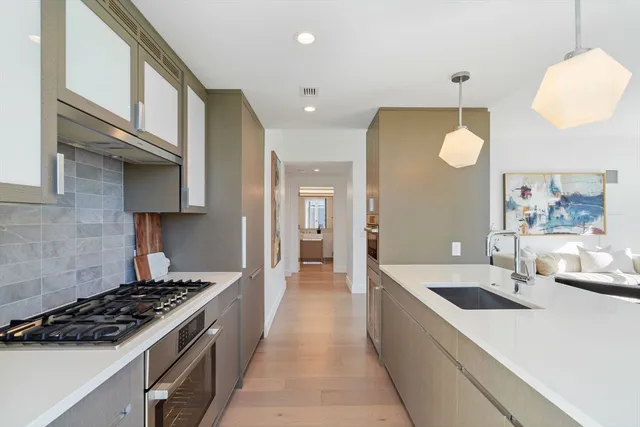 a large kitchen with stainless steel appliances granite countertop a lot of counter space
