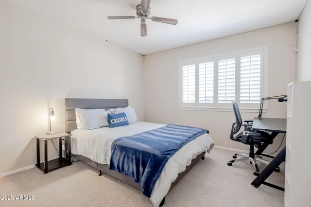 a bedroom with a bed a chair and a chandelier