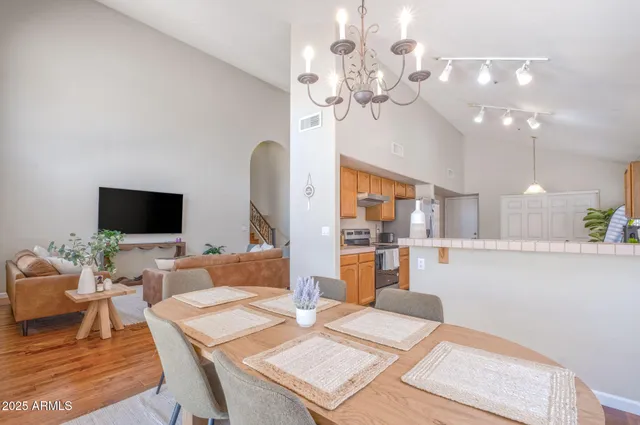a living room with furniture a chandelier and a flat screen tv