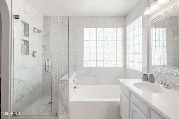 a bathroom with a granite countertop sink a large mirror and a bathtub