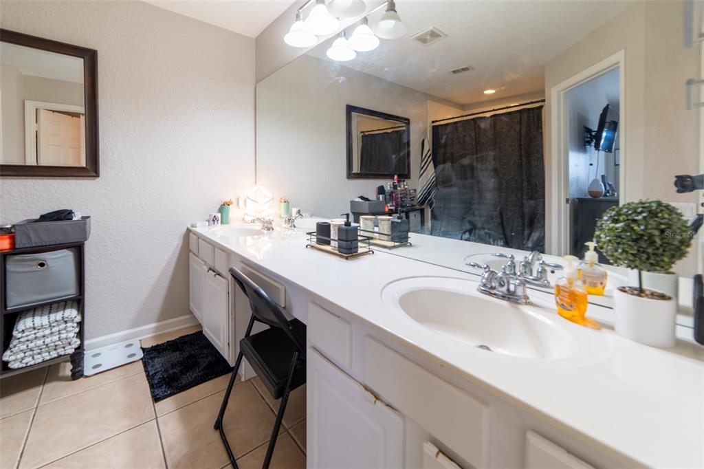 1041 Enclair Street Orlando, FL 32828 - Photo 11 of 62 a bathroom with a sink double vanity granite and a mirror