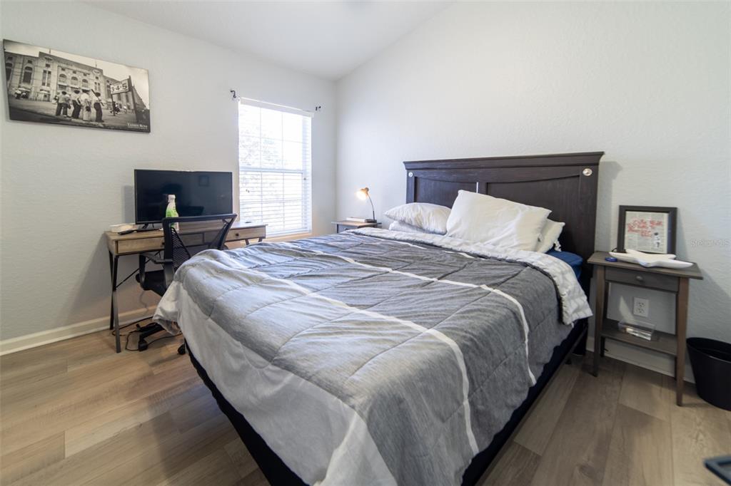 1041 Enclair Street Orlando, FL 32828 - Photo 15 of 62 a bedroom with a bed and a flat screen tv