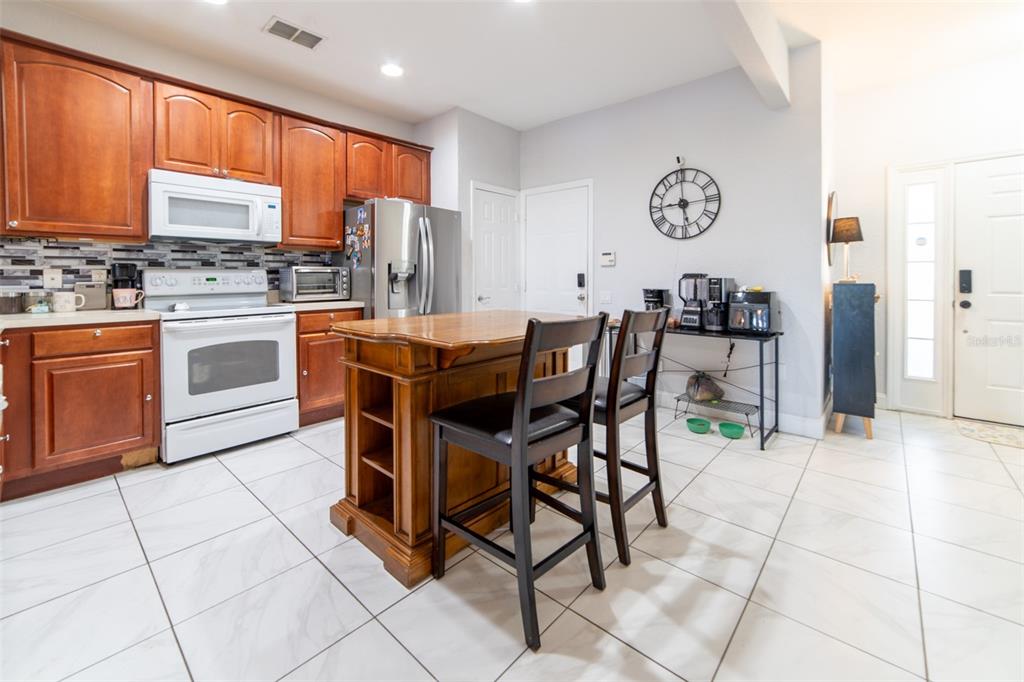 1041 Enclair Street Orlando, FL 32828 - Photo 21 of 62 a kitchen with stainless steel appliances granite countertop a stove a sink a dining table and chairs