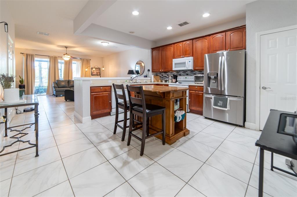 1041 Enclair Street Orlando, FL 32828 - Photo 31 of 62 a kitchen with stainless steel appliances granite countertop a refrigerator and a stove top oven