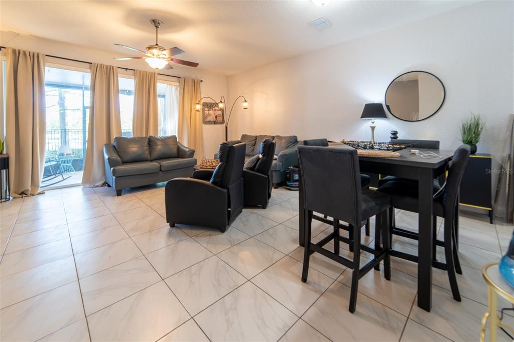 1041 Enclair Street Orlando, FL 32828 - Photo 35 of 62 a living room with furniture a two sinks a dining table and a chandelier