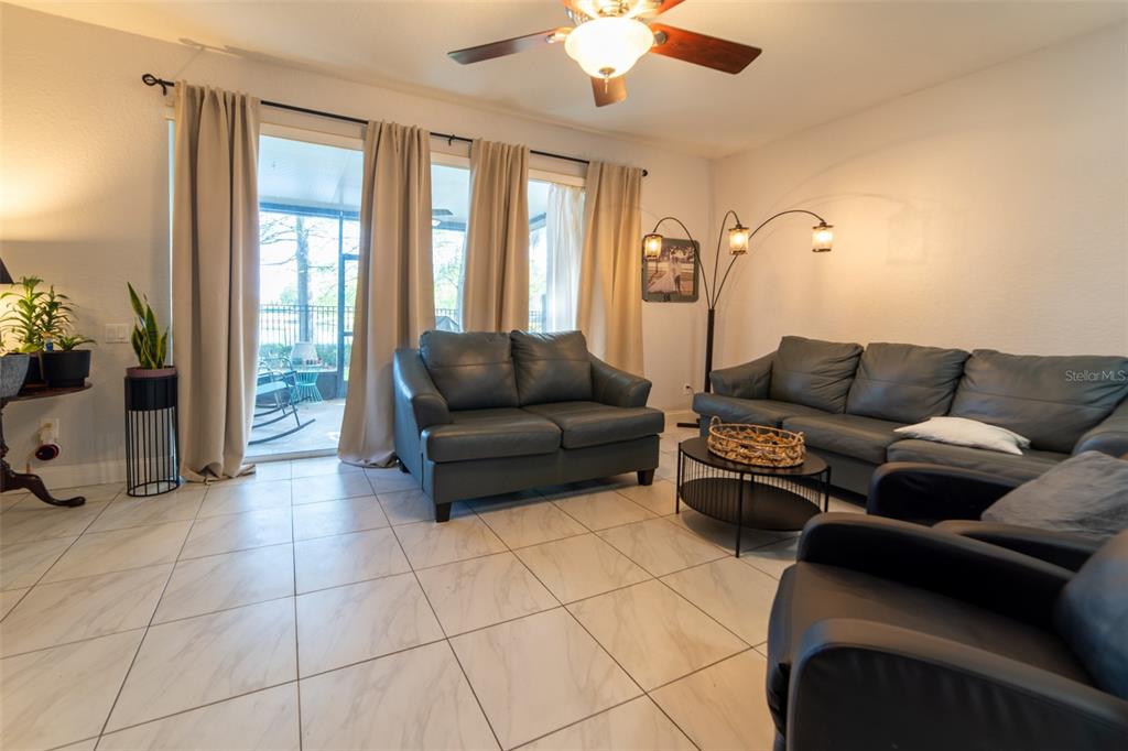 1041 Enclair Street Orlando, FL 32828 - Photo 37 of 62 a living room with furniture and a floor to ceiling window