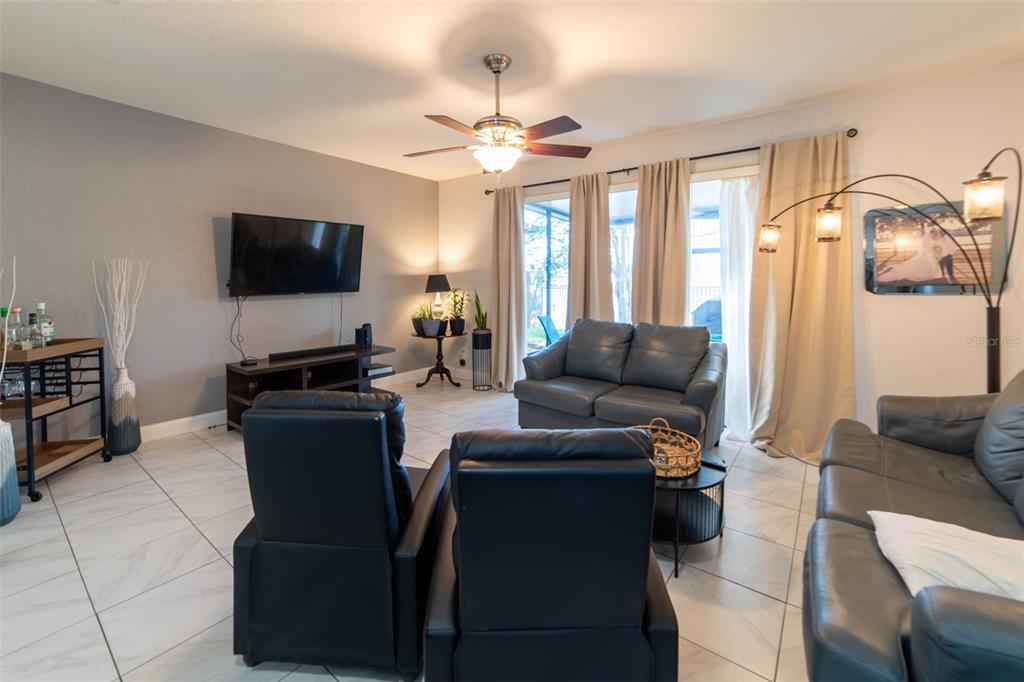 1041 Enclair Street Orlando, FL 32828 - Photo 39 of 62 a living room with furniture and a flat screen tv