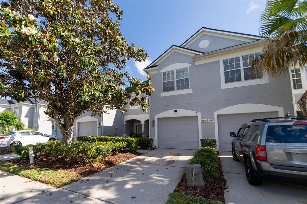 1041 Enclair Street Orlando, FL 32828 - Photo 4 of 62 a front view of a house with a garden
