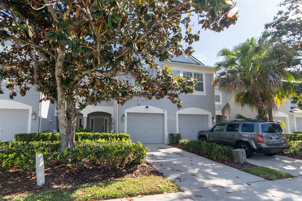 1041 Enclair Street Orlando, FL 32828 - Photo 5 of 62 a front view of a house with a garden and trees