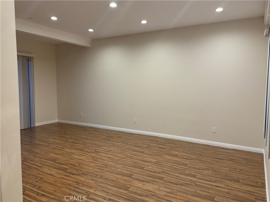 9951 Marcus Avenue, Unit 104 Tujunga, CA 91042 - Photo 14 of 16 an empty room with wooden floor and natural light
