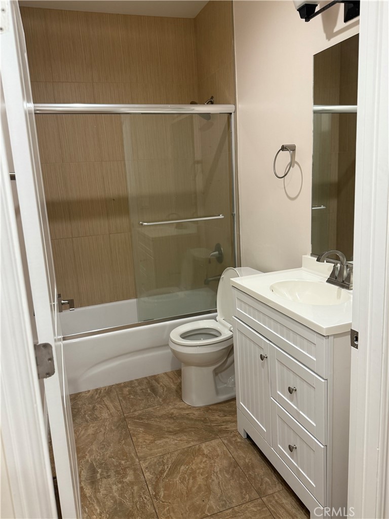 9951 Marcus Avenue, Unit 104 Tujunga, CA 91042 - Photo 9 of 16 a bathroom with a granite countertop toilet a sink and a shower