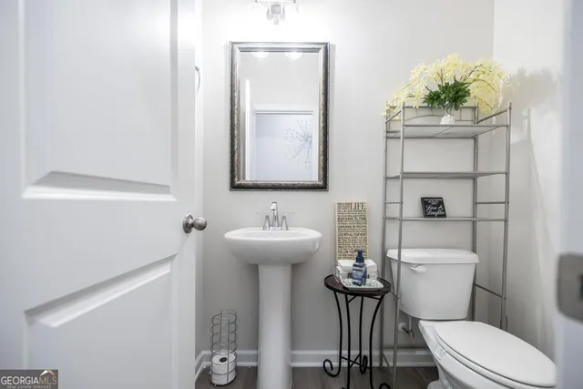 a bathroom with a toilet sink and mirror