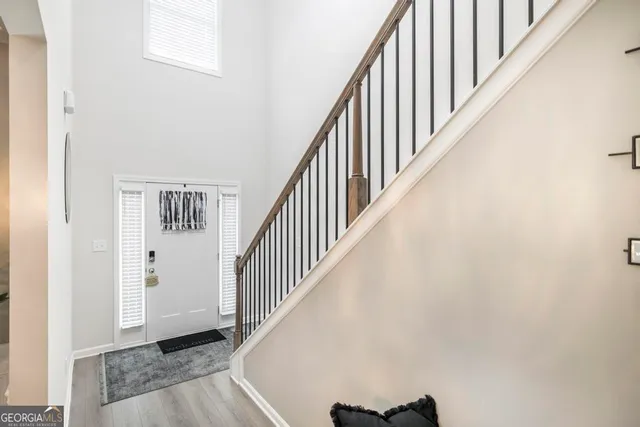 a view of staircase with railing and white walls