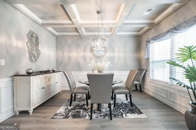 a view of a dining room with furniture a chandelier and wooden floor