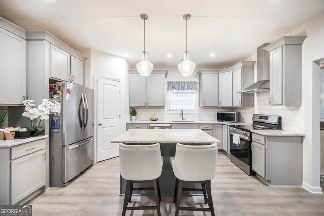 a kitchen with cabinets a sink stainless steel appliances and kitchen island
