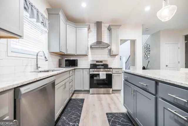 a kitchen with stainless steel appliances granite countertop a sink stove and refrigerator