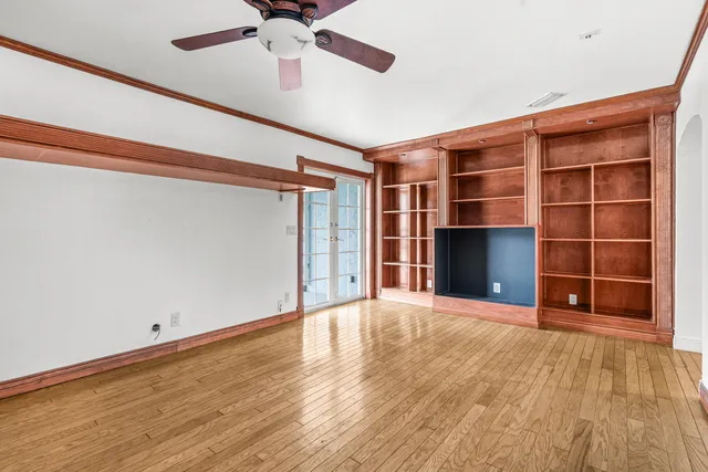 a view of an empty room with a fireplace and a window