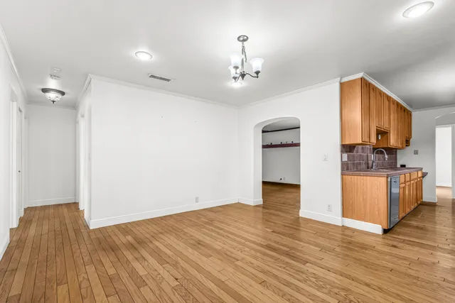 a view of a kitchen with wooden floor and a ceiling fan